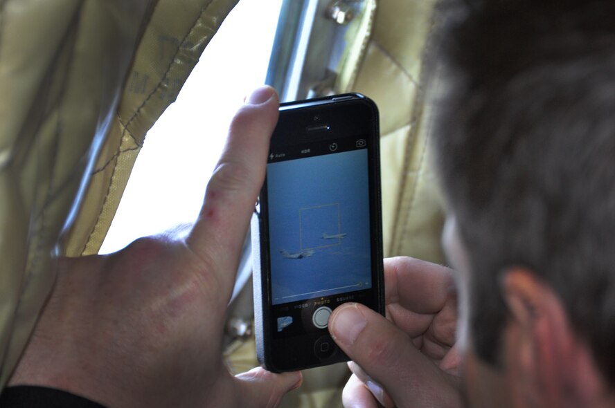 A civilian employer photographs an air to air refueling mission at MacDill Air Force Base, FL., Jan. 10, 2015. Civilian employers of Air Force Reservists, and members of the state Employers Support of the Guard and Reserve committee, took flight a KC-135 Stratotanker for a firsthand look at an in-air refueling mission. (U.S. Air Force photo/Senior Airman Xavier Lockley)