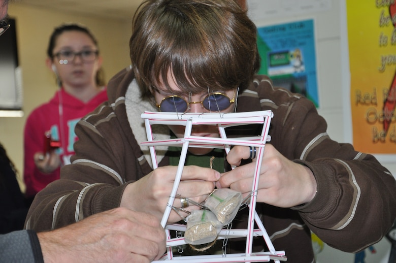 Tristen Henley, eighth grade student at Seoul American Middle School, places two sandbags on his tower during the earthquake tower challenge at Seoul American Middle School.