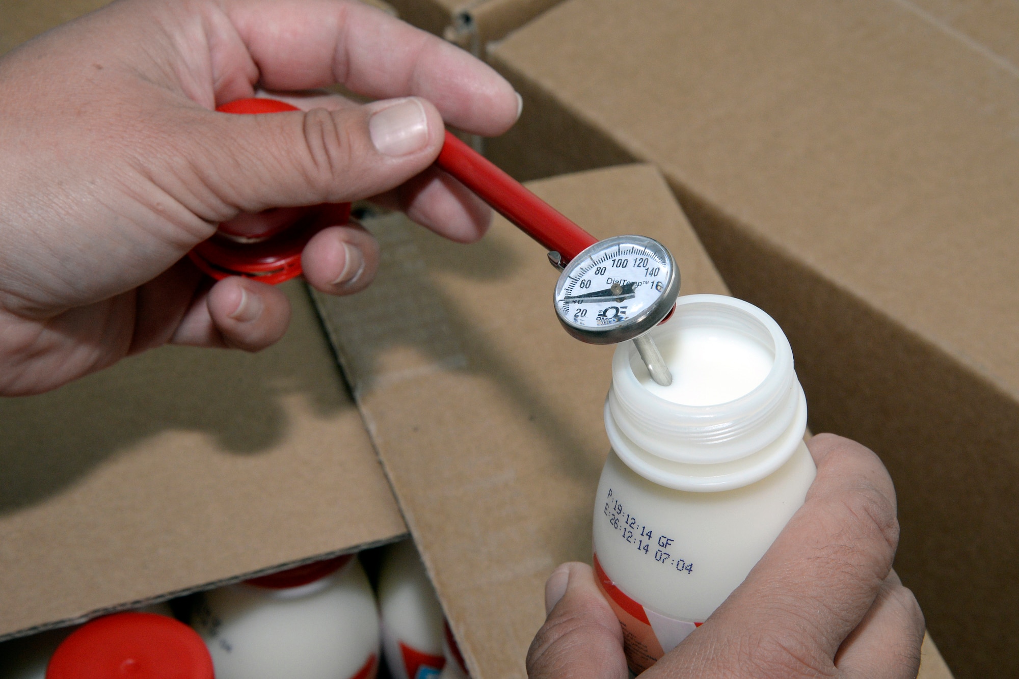 Tech. Sgt. Jenn, public health technician, tests the temperature of a bottle of milk during an inspection of the Oasis Dining Facility at an undisclosed location in Southwest Asia Dec. 23, 2014. The public health team inspects food temperatures and preparation as well as food and public facilities for safety reasons. Jenn is currently deployed from Offut Air Force Base, Neb., and is a native of Vallejo, Calif. (U.S. Air Force photo/Tech. Sgt. Marie Brown)