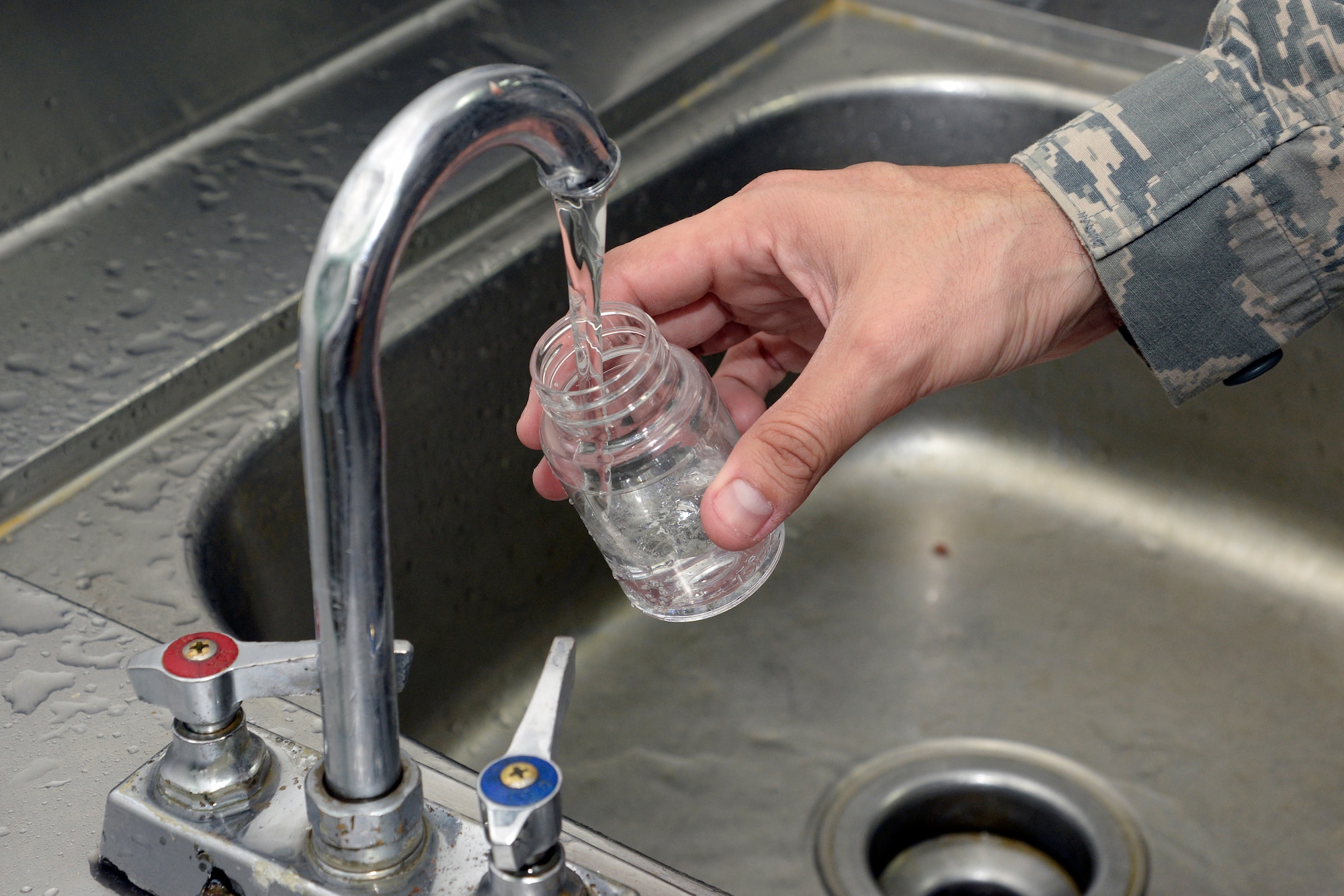 Staff Sgt. Dennis, bioenvironmental engineering technician, takes a water sample from the water supply at the Oasis Dining Facility at an undisclosed location in Southwest Asia Dec. 24, 2014. Bacteriological food is added to the water sample and incubated for 24 hours to measure the amount of total coliforms and the presence or absence of e-coli. Dennis is currently deployed from Joint Base San Antonio, Texas and is a native of San Antonio, Texas. (U.S. Air Force photo/Tech. Sgt. Marie Brown)