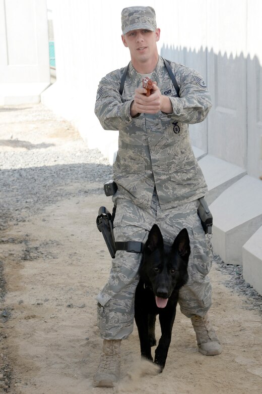 Staff Sgt. Matthew, military working dog handler, and his MWD Kalo perform a tactical obedience maneuver during a training exercise at an undisclosed location in Southwest Asia Jan. 5, 2015. Receiving on average of at least 30 training sessions a month, the MWD teams train on as many realistic scenarios as possible. Matthew is currently deployed from Nellis Air Force Base, Nev. (U.S. Air Force photo/Tech. Sgt. Marie Brown)