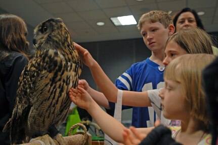 Children of servicemembers pet a European eagle owl at the Army National Guard Readiness Center in Arlington, Va., April 22, 2010. The owl was one of several birds of prey that were brought in for the Guard's Earth Day/Take your Child to Work Day celebration. Other activities for the children included face painting, musical guests, aerobics and science demonstrations.