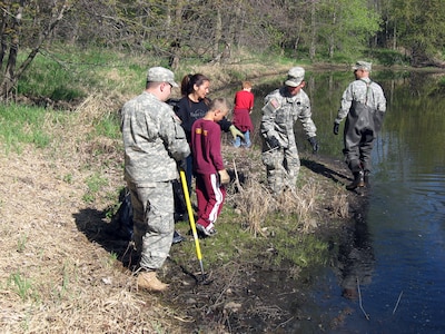 The 147th and 247th Finance Detachments of the Minnesota National Guard joined forces with local leaders to clean up their community in Roseville, Minn., April 18, 2010. The two finance units along with local residents picked up garbage, glass and other debris at local parks. Spc. Steven VanCourt, Cpl. Jason Mosher and Staff Sgt. Eric Stensvold, all of the 247th Finance Detachment, help dredge the lake.