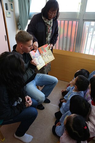 Lance Cpl. Cody Freeman, an electrician with Combat Logistics Company 36 aboard Marine Corps Air Station, Iwakuni, Japan, and a teacher from Kinnan Hoikuen in Iwakuni city, read English storybooks to students during a community relations visit, Jan. 9, 2015. Marines from CLC-36 visited the school to teach basic English, interact with the Japanese children and play popular American games. CLC-36’s continual interaction with this school helps preserve an important bond between the Marines and local Japanese.