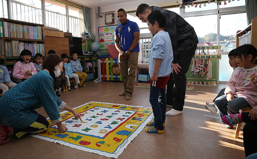 Staff Sgt. John Skehan, family readiness officer for Combat Logistics Company 36 aboard Marine Corps Air Station, Iwakuni, Japan and Lance Cpl. Portee Eljeria, a supply clerk with CLC-36, teach students the English alphabet during a visit to Kinnan Hoikuen in Iwakuni city during a community relations visit, Jan. 9, 2015. Marines from CLC-36 visited the school to teach basic English, interact with the Japanese children and play popular American games. Musical chairs, duck-duck-goose, and rock-paper-scissors are just a few of the playful activities the Marines and children enjoyed together.