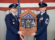 Col. Darren Halford, 9th Operations Group commander (left), presents Chief Master Sgt. James Crites, 9th Operations Group superintendent, his shadow box during Crites retirement ceremony at Beale Air Force Base, Calif., Jan. 9, 2015. Crites served more than 30 years in the Air Force. (U.S. Air Force photo by Senior Airman Bobby Cummings/Released)