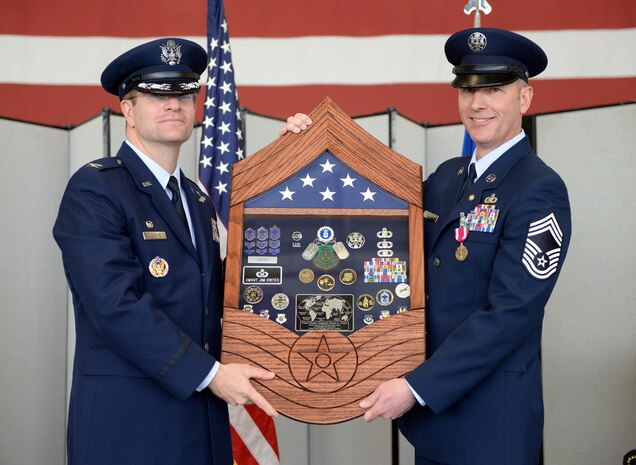 Col. Darren Halford, 9th Operations Group commander (left), presents Chief Master Sgt. James Crites, 9th Operations Group superintendent, his shadow box during Crites retirement ceremony at Beale Air Force Base, Calif., Jan. 9, 2015. Crites served more than 30 years in the Air Force. (U.S. Air Force photo by Senior Airman Bobby Cummings/Released)