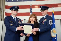Mrs. Hyun Crites (Center), wife of Chief Master Sgt. James Crites, 9th Operations Group superintendent (right), is presented the Military Spouse Medal during her husband’s retirement ceremony at Beale Air Force Base, Calif., Jan. 9, 2015. The couple met while Crites was serving in Korea. (U.S. Air Force photo by Senior Airman Bobby Cummings/Released)