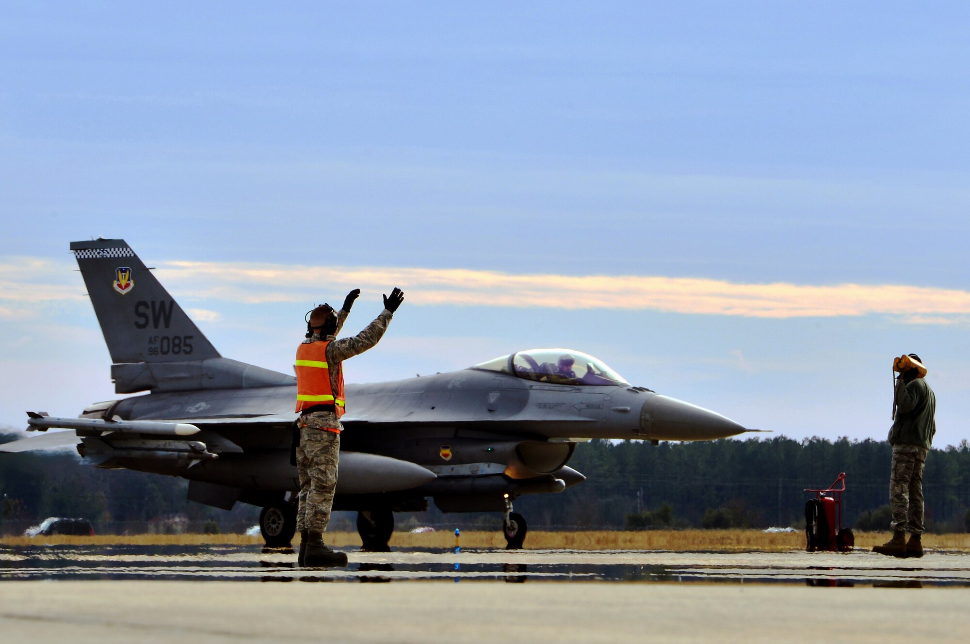 A U.S. Air Force tactical aircraft maintainer assigned to the 20th Aircraft Maintenance Squadron marshals an F-16CM Fighting Falcon as the pilot returns from a flight at Shaw Air Force Base, S.C., Jan. 7, 2015. F-16 Fighter pilots fly multiple sorties each week to keep their skills sharp for real world situations. (U.S. Air Force photo by Staff Sgt. Kenny Holston/Released)