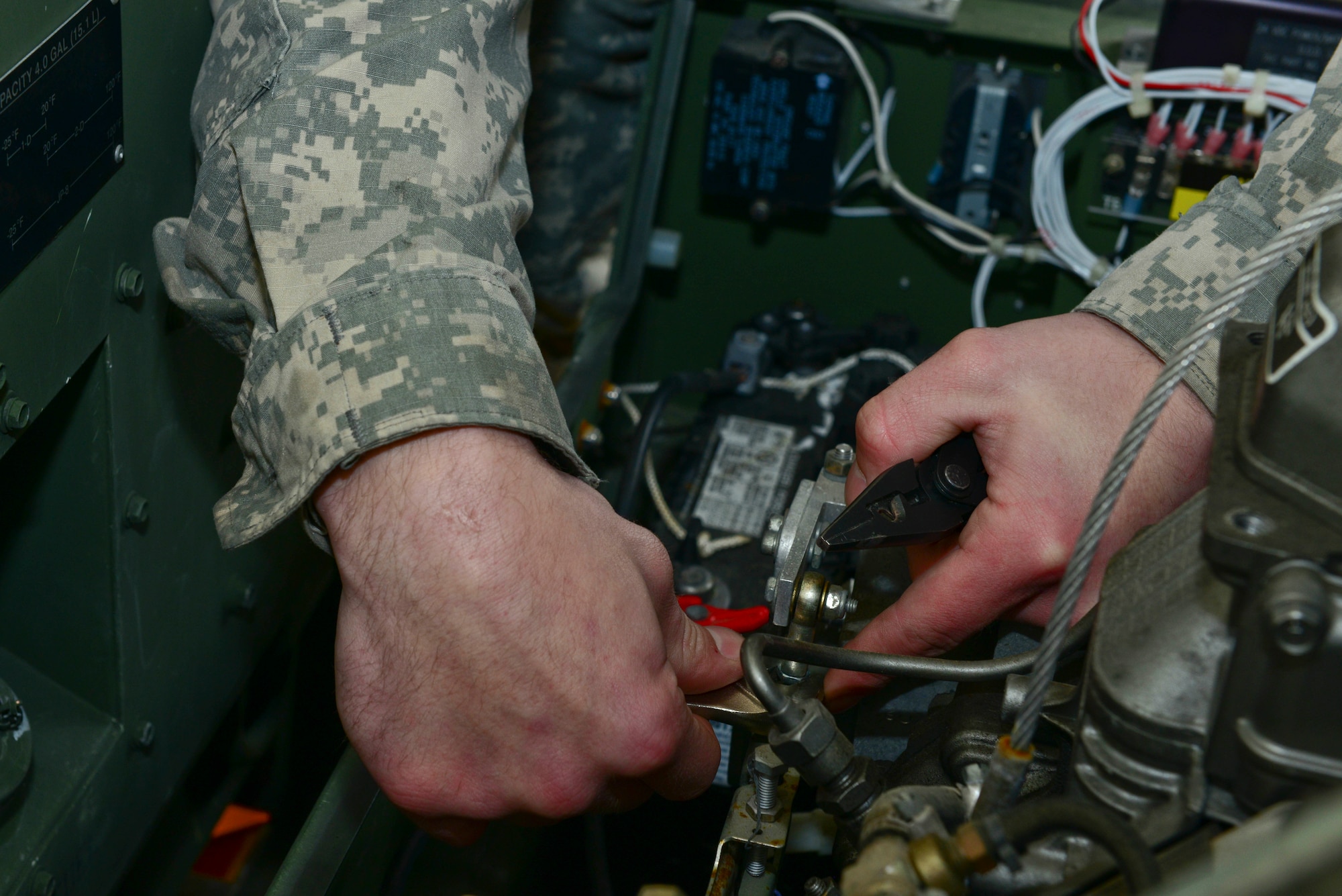U.S. Army Pfc. Michael Althiser, 155th Inland Cargo Transfer Company, 53rd Transportation Battalion (Movement Control), 7th Transportation Brigade (Expeditionary) power generation equipment repairer, works on a generator at the 155th ICTC motor pool at Fort Eustis, Va., Jan. 7, 2015. Althiser adjusted the actuator and tested the battery charging circuit on one of many generators Soldiers must maintain at the motor pool.  (U.S. Air Force photo by Senior Airman Kimberly Nagle/Released)