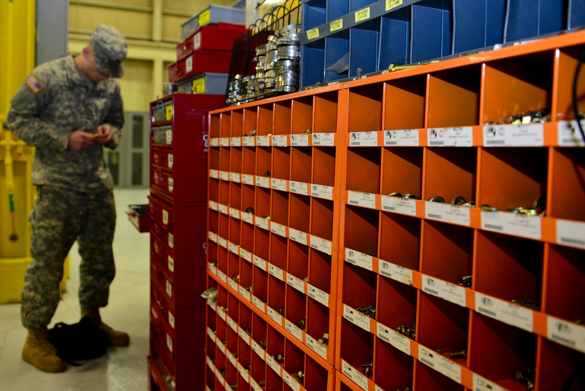 U.S. Army Pfc. Michael Althiser, 155th Inland Cargo Transfer Company, 53rd Transportation Battalion (Movement Control), 7th Transportation Brigade (Expeditionary) power generation equipment repairer, selects items needed to repair a generator at the 155th ICTC motor pool at Fort Eustis, Va., Jan. 7, 2015. Althiser used multiple fuses to keep the generators at the motor pool running properly so they can be later utilized for deployments or field missions. (U.S. Air Force photo by Senior Airman Kimberly Nagle/Released)
