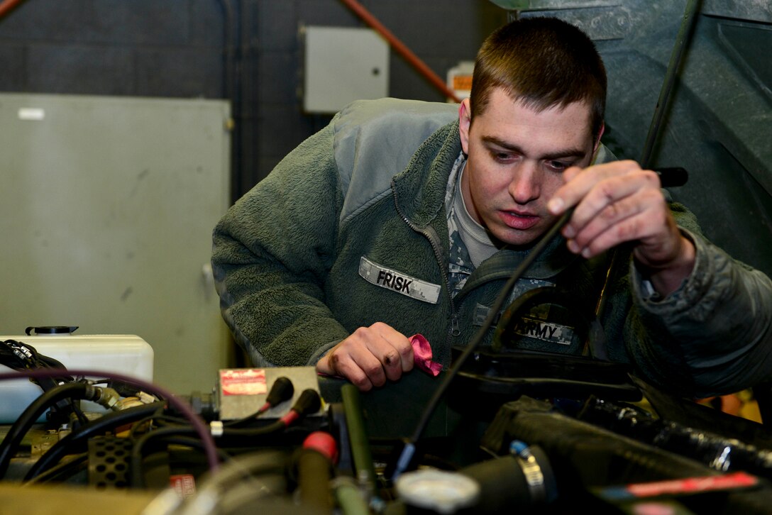U.S. Army Cpl. Christopher Frisk, 155th Inland Cargo Transfer Company, 53rd Transportation Battalion (Movement Control), 7th Transportation Brigade (Expeditionary) wheel vehicle mechanic, checks for possible leaks in a Humvee at the 155th ICTC motor pool at Fort Eustis, Va., Jan. 7, 2015. Motor pool components, such as Humvees and generators, are used for deployments, local missions and training. (U.S. Air Force photo by Senior Airman Kimberly Nagle/Released)

