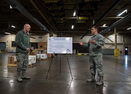 Staff Sgt. Brandon Doyle briefs Lt. Gen. Carlton D. Everhart II, 18th Air Force commander, about the 437th Aerial Port Squadron Port Dawg University, a program which streamlines the process of on-the-job training Jan. 8, 2015, at Joint Base Charleston S.C. While visiting JB Charleston, the general toured the 437th Maintenance Group, the 437th Aerial Port Squadron, the 437th Operations Support Squadron and other units across the wing to interact with the Airmen and civilians who work to provide precise, reliable airlift worldwide every day. Doyle is a member of the 437th Aerial Port Squadron. (U.S. Air Force photo/Senior Airman Jared Trimarchi)  