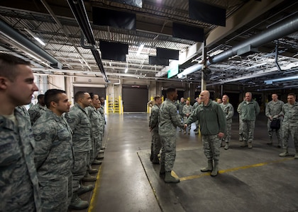 Lt. Gen. Carlton D. Everhart II, 18th Air Force commander, coins Airman 1st Class John Woodruff for his outstanding work ethic in the 437th Aerial Port Squadron warehouse Jan. 8, 2015, at Joint Base Charleston S.C. While visiting JB Charleston, the general toured the 437th Maintenance Group, the 437th Aerial Port Squadron, the 437th Operations Support Squadron and other units across the wing to interact with the Airmen and civilians who work to provide precise, reliable airlift worldwide every day.  (U.S. Air Force photo/Senior Airman Jared Trimarchi)  