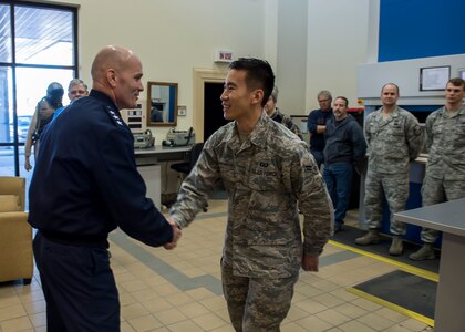Lt. Gen. Carlton D. Everhart II, 18th Air Force commander, coins Airman 1st Class Mario Mastrofrancesco a star performer in the 437th Aircrew Flight Equipment shop Jan. 8, 2015, at Joint Base Charleston S.C. While visiting JB Charleston, the general toured the 437th Maintenance Group, the 437th Aerial Port Squadron, the 437th Operations Support Squadron and other units across the wing to interact with the Airmen and civilians who work to provide precise, reliable airlift worldwide every day.   Mastrofrancesco is a member of the 437th AFE shop. (U.S. Air Force photo/Senior Airman Jared Trimarchi) 