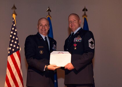 Lt. Gen. Carlton D. Everhart II, 18th Air Force commander, presents Chief Master Sgt. Christopher Robinson with his Bronze Star Jan. 8, 2015, in the base theater at Joint Base Charleston S.C., during a ceremony honoring Robinson’s accomplishments while deployed to Afghanistan. While visiting JB Charleston, the general toured the 437th Maintenance Group, the 437th Aerial Port Squadron, the 437th Operations Support Squadron and other units across the wing to interact with the Airmen and civilians who work to provide precise, reliable airlift worldwide every day. Robinson is a member of the 437th Maintenance Group.  (U.S. Air Force photo/Senior Airman Jared Trimarchi) 