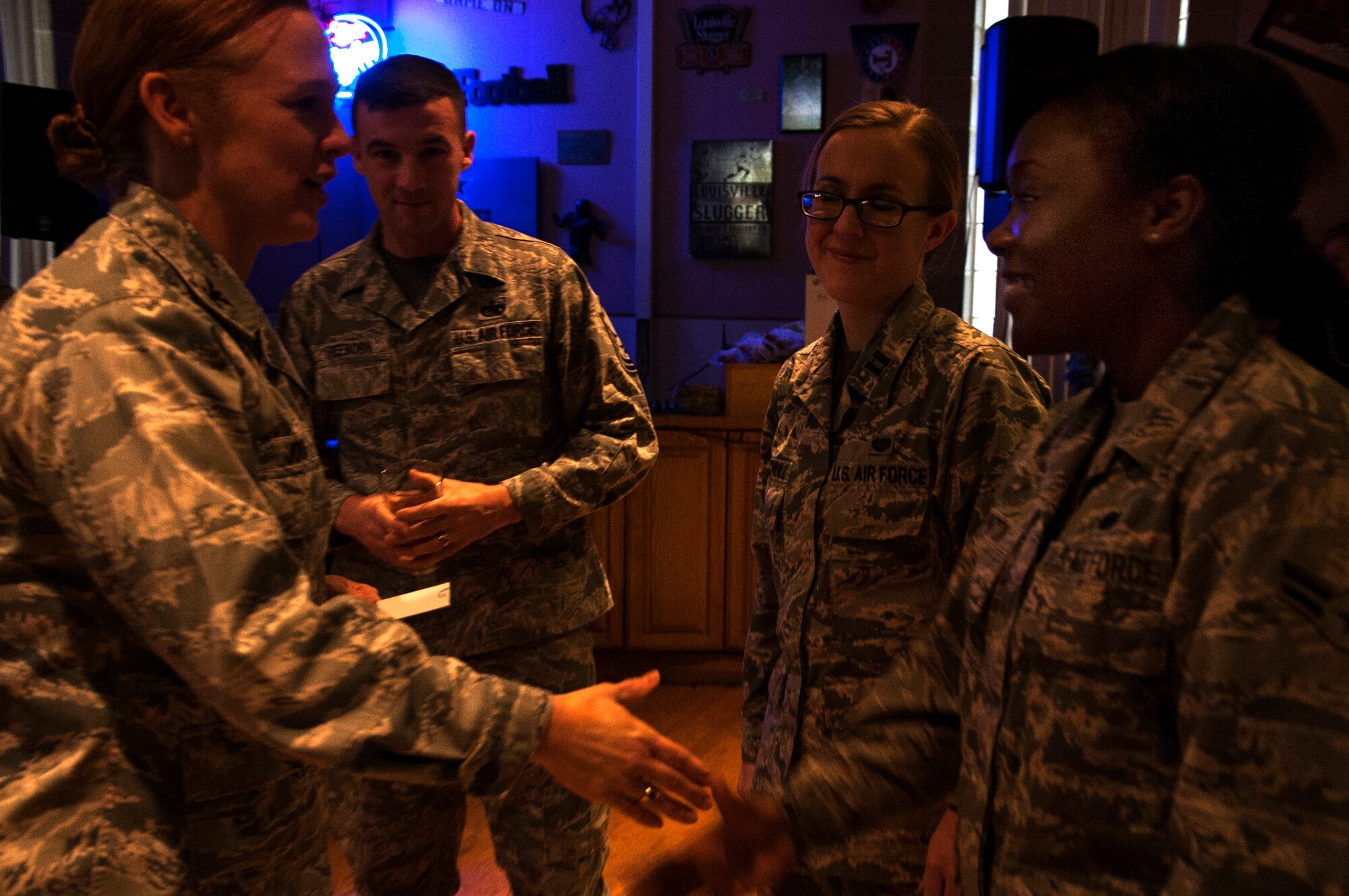 GOODFELLOW AIR FORCE BASE, Texas –  Col. Kimberlee P. Joos, 17th Training Wing Commander, shakes hands with Airman 1st Class Jebree M. Hinton, 17th TRW Legal Office paralegal journeyman, for winning Operation Bar Rescue at the Neon Cactus Jan. 9. Operation Bar Rescue was a contest to pitch a new theme and design for the bar. (U.S. Air Force photo/ Airman 1st Class Scott Jackson)