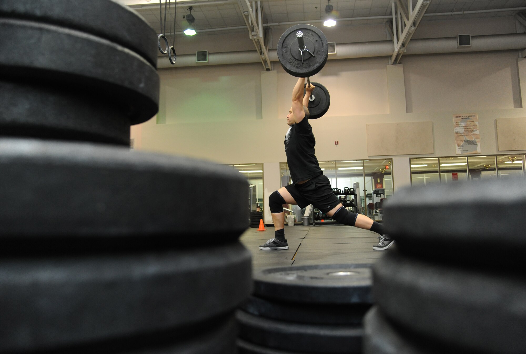 The spouse of Col. Maureen Harback, 81st Diagnostic and Therapeutics Squadron commander, does a “clean and jerk” lift during his warm-up Jan. 9, 2015, at the Dragon Fitness Center, Keesler Air Force Base, Miss. He practices various types of Olympic lifting and gymnastic movements along with running, rowing and biking exercises. He believes that mixing up workouts keeps people interested and coming back. Harback’s New Year’s resolution is to earn Defense of Department certification. (U.S. Air Force photo by Kemberly Groue)