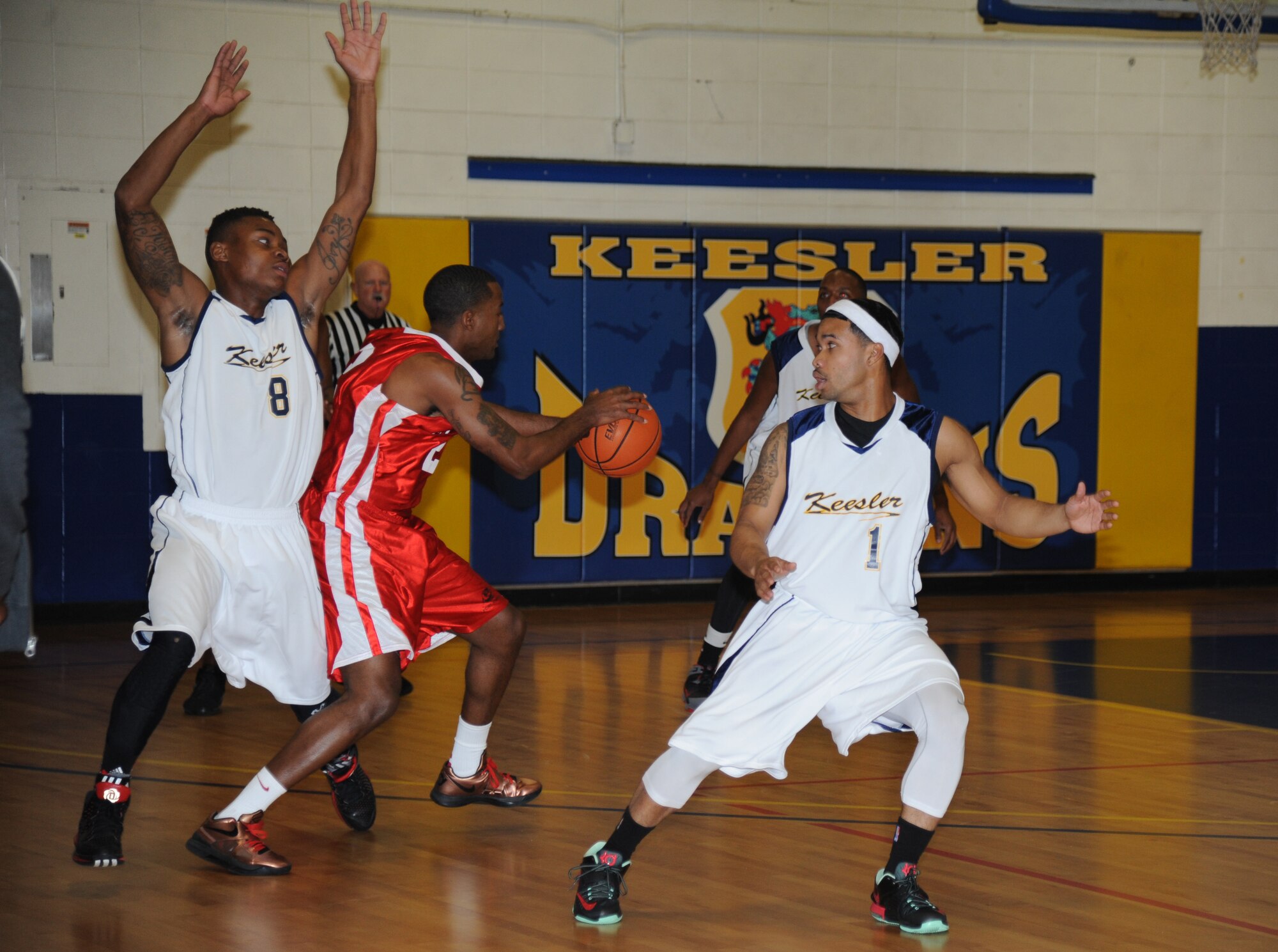 Stephen Ivy and Mario McKnight, Keesler, play defense as Benjamin Charles, Fort Gordon, Ga., drives the ball between them towards the goal during the men’s varsity basketball competition Jan. 10, 2015, at the Blake Fitness Center, Keesler Air Force Base, Miss. Fort Gordon defeated Keesler, 89-67.  (U.S. Air Force photo by Kemberly Groue)