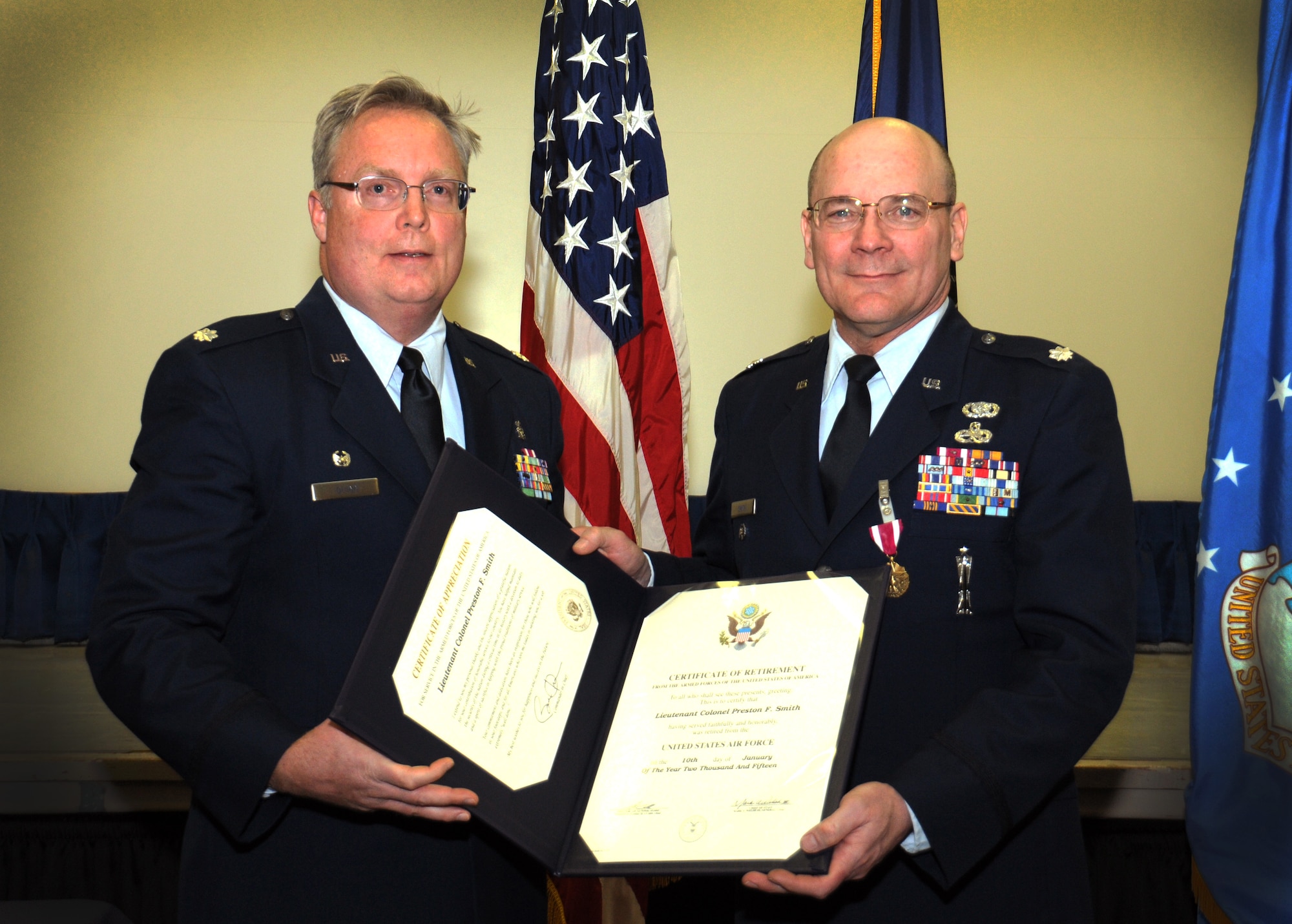 Lt. Col. John Quinn (left), 111th Medical Group commander, presents Lt. Col. (ret.) Preston Smith, former 111th Attack Wing medical administrative officer, with certificates for honorable service during a retirement ceremony held Jan. 10, 2015 at the wing headquarters building on Horsham Air Guard Station, Pa. Smtih's career spanned 39 years in both the active-duty Air Force and Air National Guard. (U.S. Air National Guard photo by Michael Shaffer/Released)