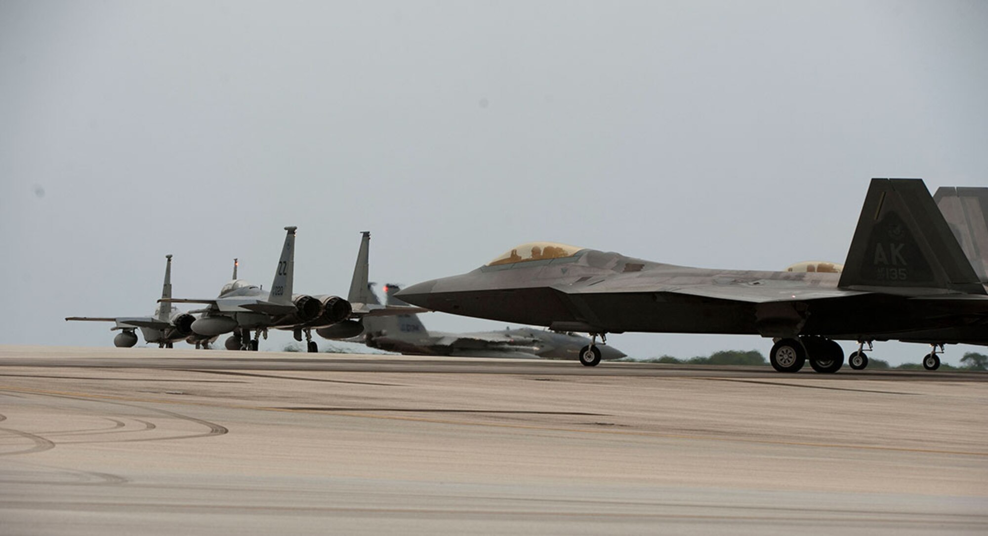 A U.S. Air Force F-15C Eagle and F-22 Raptor taxi during Valiant Shield 2014 in anticipation of operations in a joint airspace environment, Sept. 16, 2014, Andersen Air Force Base, Guam. Valiant Shield is a U.S.-only exercise, integrating an estimated 18,000 U.S. Navy, Air Force, U.S. Army and U.S. Marine Corps personnel, more than 200 aircraft and 19 surface ships, offering real-world joint operational experience to develop capabilities that provide a full range of options to defend U.S. interests and those of its allies and partners. (U.S. Air Force Photo by Staff Sgt. William Banton/Released)