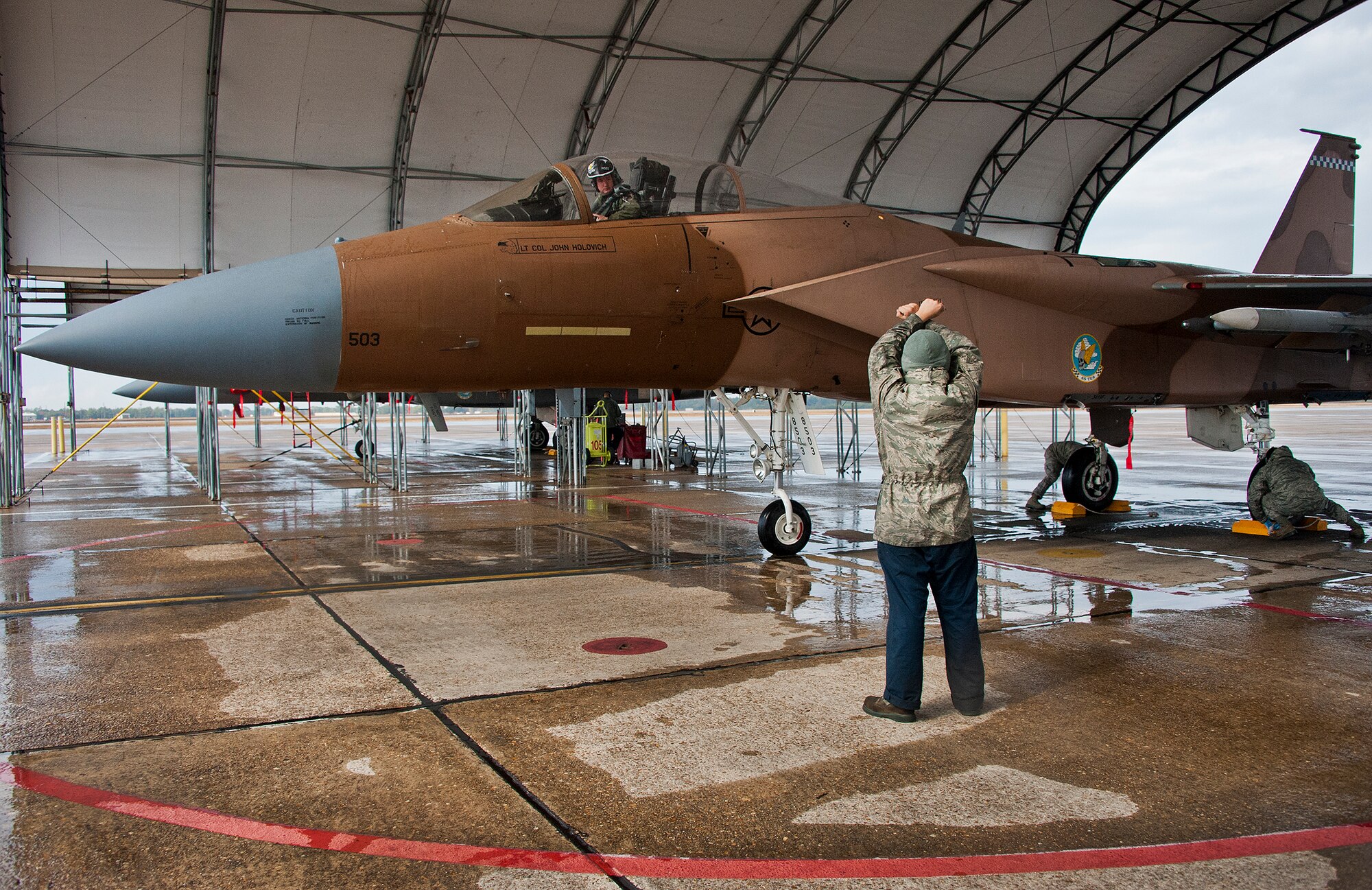 Senior Airman Clifton Lovar, of the 96th Aircraft Maintenance Squadron marshals an F-15C Eagle into its parking spot while chocks are placed around the wheels to steady the aircraft at Eglin Air Force Base, Fla. on Dec. 19.  A team of two recovery assistants will then safe the aircraft for inspection.  All the test aircraft for the 96th Test Wing and the 85th Test and Evaluation Squadron are maintained by the 96th AMXS. (U.S. Air Force photo/Ilka Cole)