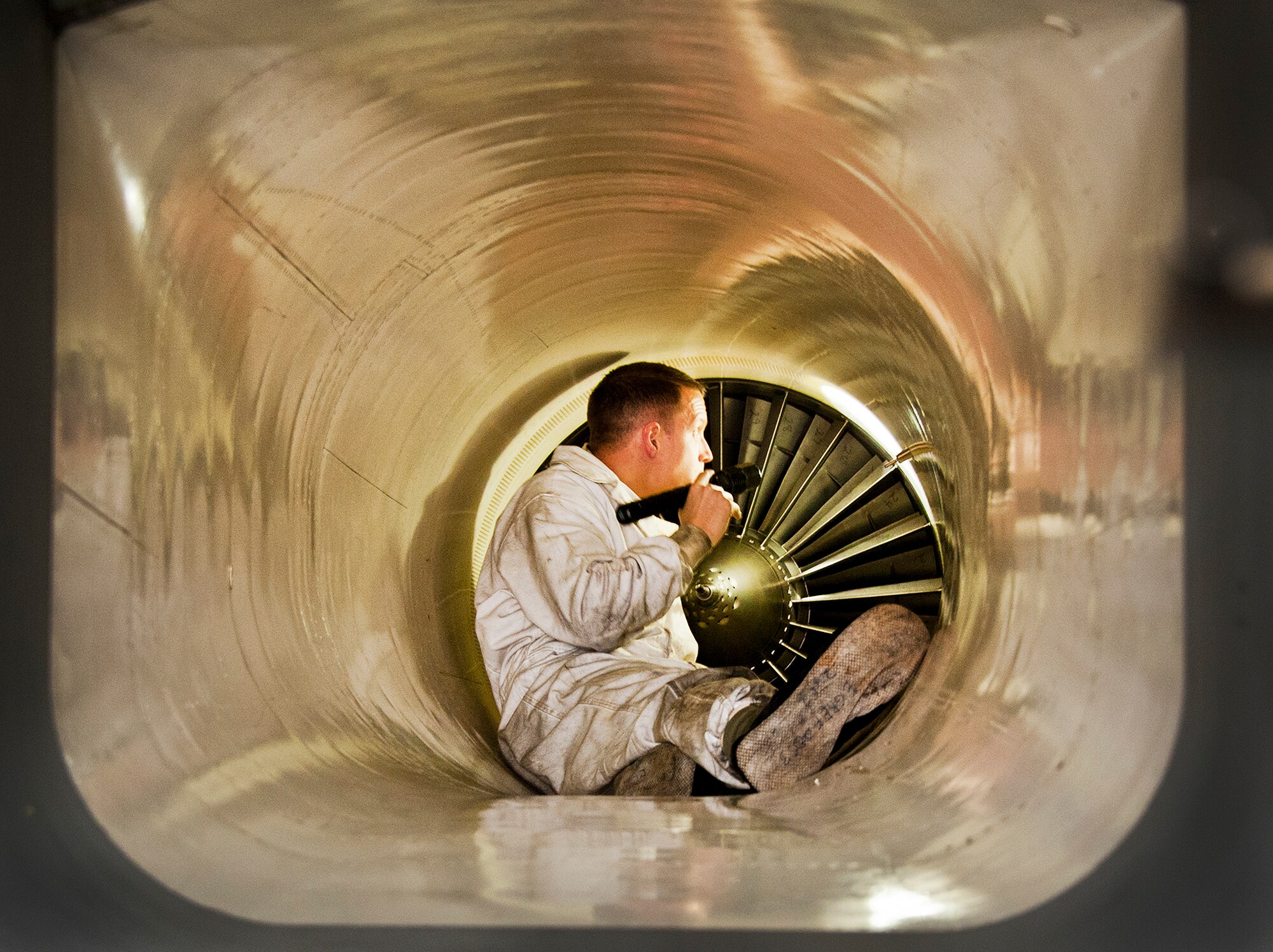 Staff Sgt. Michael Tkach, of the 96th Aircraft Maintenance Squadron, sits inside the intake of an F-15 Eagle to inspect the engine fan blades at Eglin Air Force Base, Fla. on Dec. 19.  The aircraft maintainers complete these inspections after each flight to ensure there is no damage to the intake or the engine fan blades. All the test aircraft for the 96th Test Wing and the 85th Test and Evaluation Squadron are maintained by the 96th AMXS. (U.S. Air Force photo/Ilka Cole)