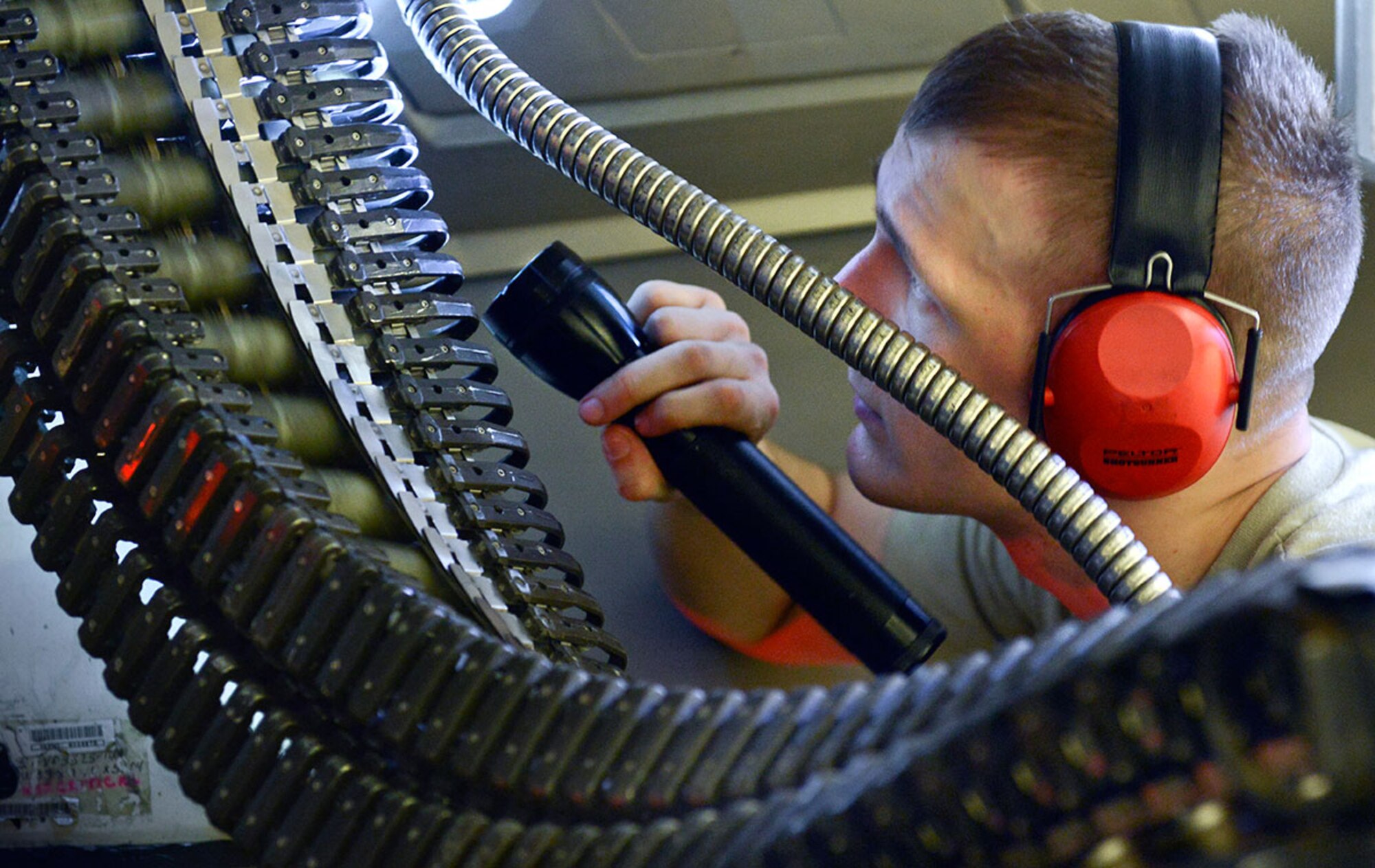 Airman 1st Class Charles Pole, an aircraft armament systems specialist examines his Universal Amunition Loading System (UAL) interface unit during an F-22 Raptor quarterly load competition at Joint Base Elmendorf-Richardson, Alaska, December 31, 2014. The winners of the match move on to the annual competition. (U.S. Air Force Photo by Airman 1st Class Kyle Johnson)