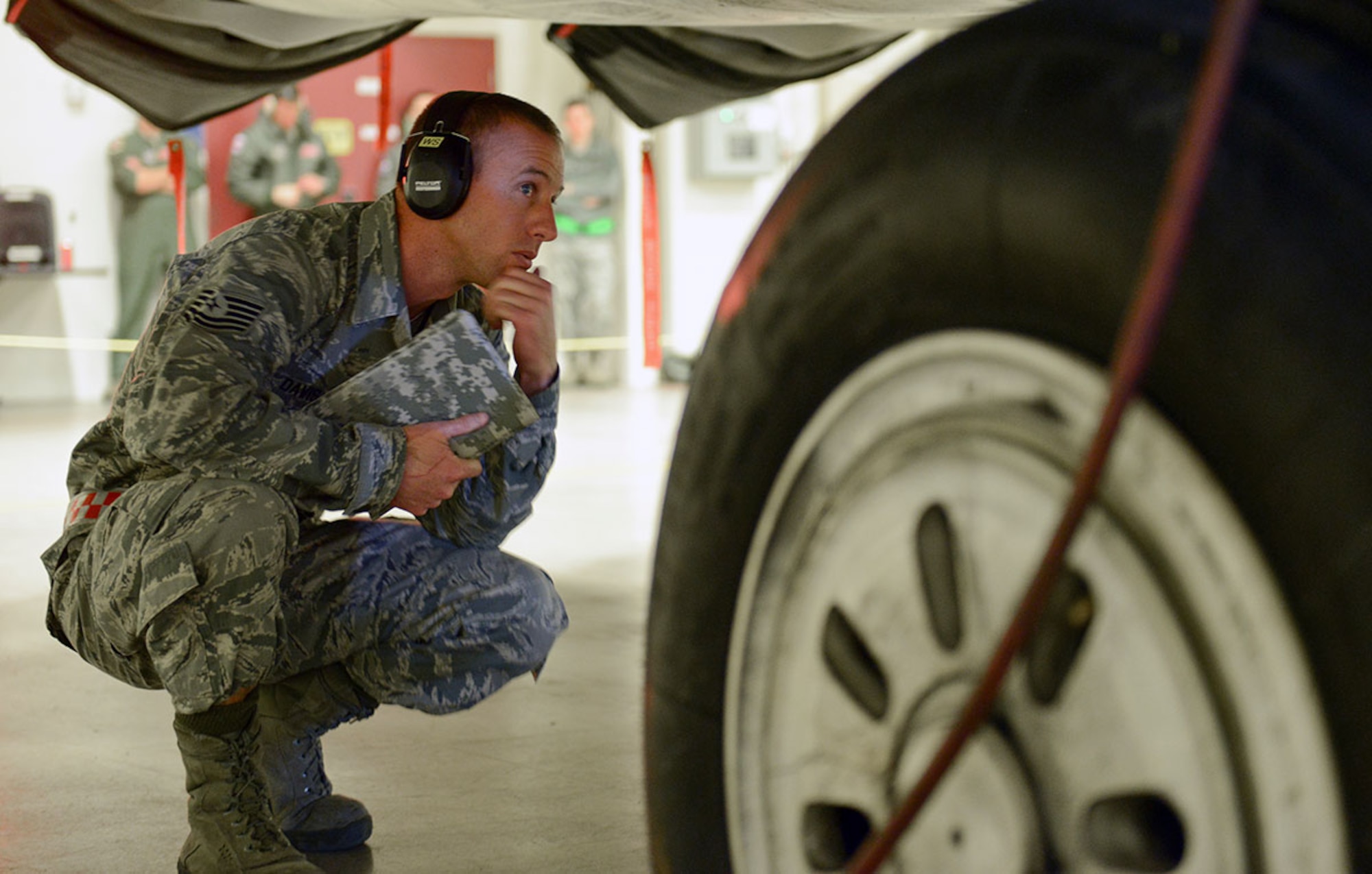 A load crew evaluator carefully examines the work of 90th AMU load crew members at an F-22 Raptor quarterly loadcrew competition at Joint Base Elmendorf-Richardson Dec. 31. The judgement of the experienced evaluators will determine who goes to the annual competition. (U.S. Air Force photo/Airman 1st Class Kyle Johnson)