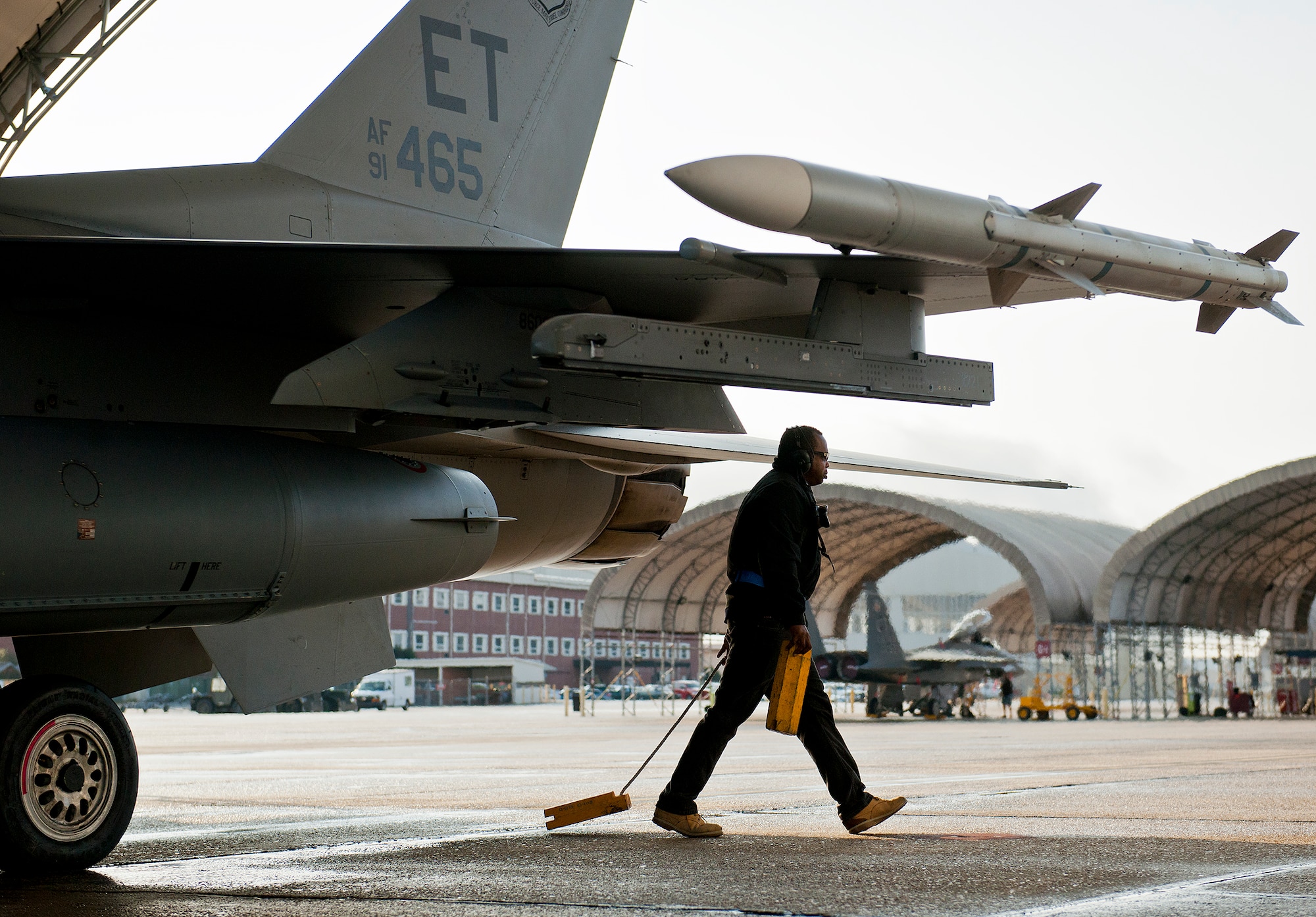 A 96th Aircraft Maintenance Squadron maintainer pulls the chocks from an F-16 Fighting Falcon prior to it taxiing for a morning sortie at Eglin Air Force Base, Fla.  The 96th AMXS is responsible for the maintenance of all the test aircraft for the 96th Test Wing and the 85th Test and Evaluation Squadron.  (U.S. Air Force photo/Samuel King Jr.)