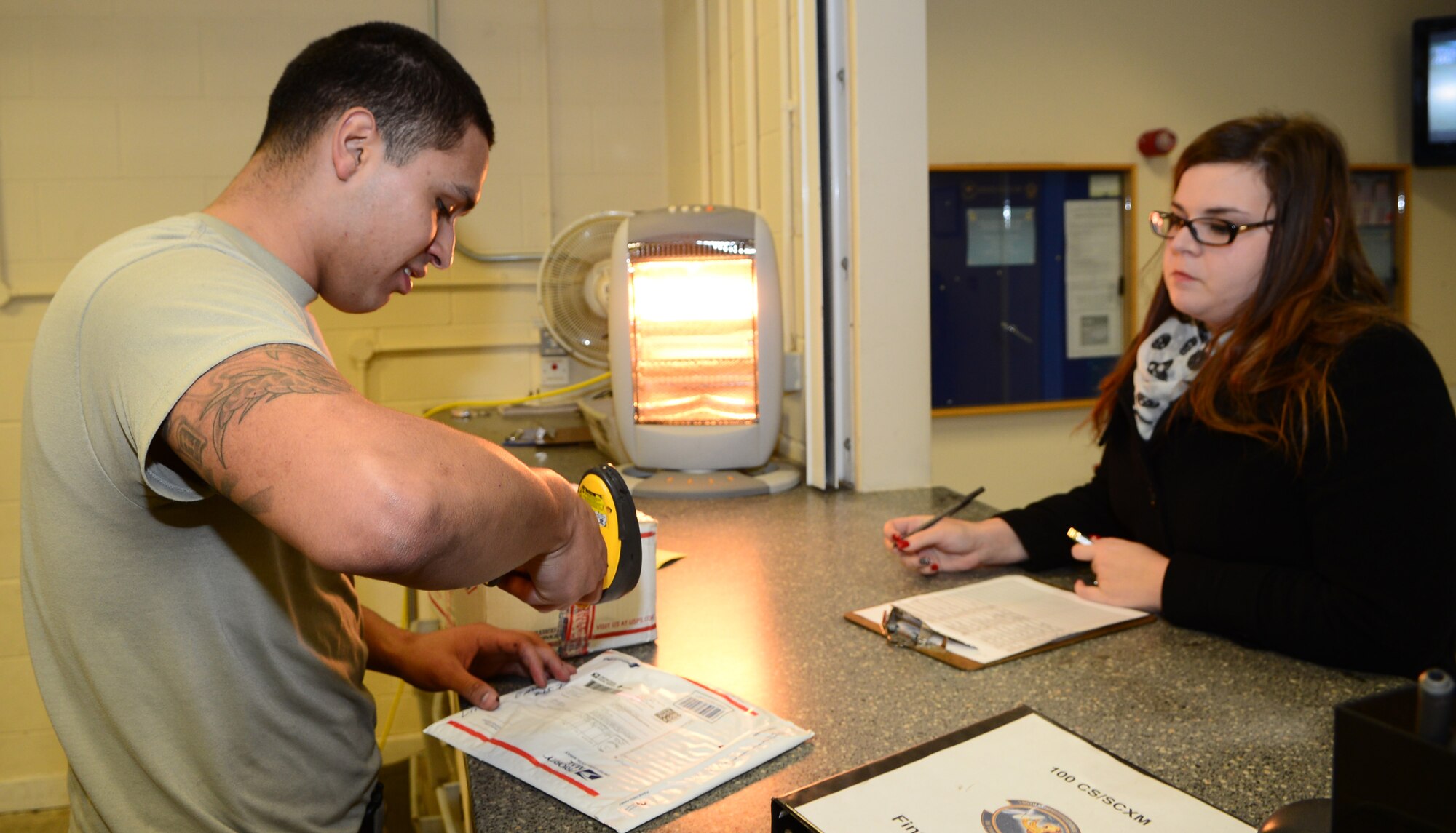 U.S. Air Force Senior Airman Oscar Campos-Ortiz, 100th Communication Squadron postal clerk from Dallas, scans a package for a customer Jan. 12, 2015, at the base post office on RAF Mildenhall, England. The RAF Mildenhall Post Office processes approximately 60,000 pounds of incoming mail, 18,000 pounds of outgoing mail and delivers more than 4,000 packages a month. (U.S. Air Force photo by Airman 1st Class Jonathan Light/Released)