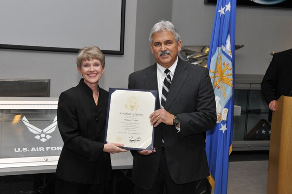 Bill Lamb, right, receives a Certificate of Service from the United States Air Force for 41 years of federal civilian service during his retirement ceremony at AEDC on Dec. 16. Lamb retired as the deputy director of the Air Force Test Center Contracting Division (AFTC/PZ) at Arnold Air Force Base. Immediate family members in attendance include Lamb’s wife Deborah, sons Shane and Brandon, and daughters Tiffany and Chelsea. Amy Foster, the director of the Arnold AFTC/PZ, is shown presenting the Certificate of Service to Lamb. (Photo by Rick Goodfriend)