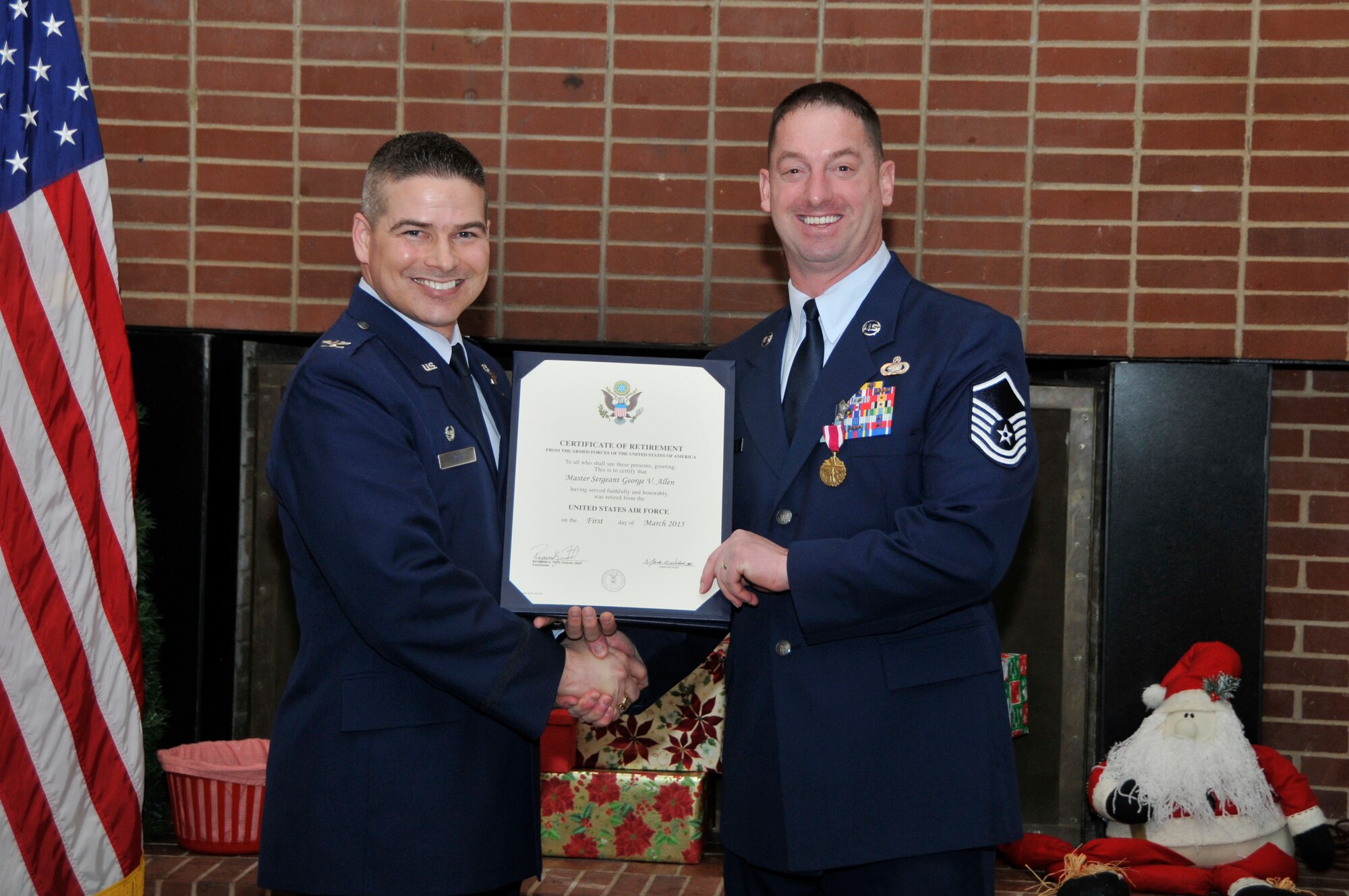 Master Sgt. George Allen, right, receives a Certificate of Retirement from the United States Air Force for 24 years of service during a retirement ceremony at AEDC on Dec. 19. Allen was assigned to AEDC for more than four years where he was the Superintendent of Fuels Management with the AEDC Test Support Division. He was accompanied by his wife Angel and sons Grant and Gage during the ceremony. Allen is shown accepting his retirement certificate from AEDC Commander Col. Raymond Toth. He also received the Meritorious Service Medal 2nd Oak Leaf Cluster Award and a Certificate of Appreciation from President Barack Obama. (Photo by Jacqueline Cowan)