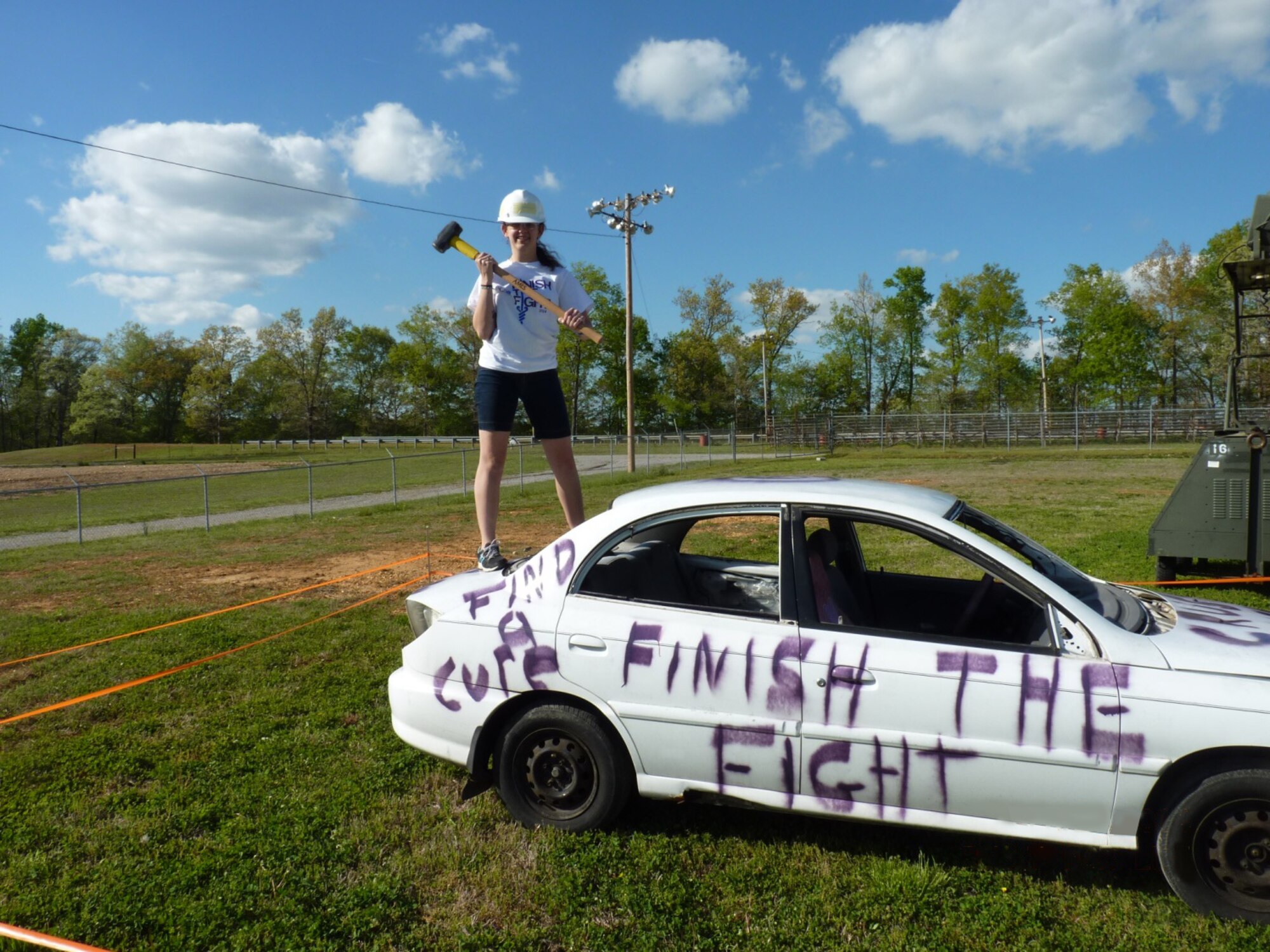 Amber Wolfe, the daughter of AEDC employee Dee and Shawn Wolfe, prepares to smash cancer by damaging a car that represents cancer at the 2014 Relay For Life in Manchester. The “Smashing Car” is a fundraiser event for team REMEMBER at the relay. (Photo provided)
