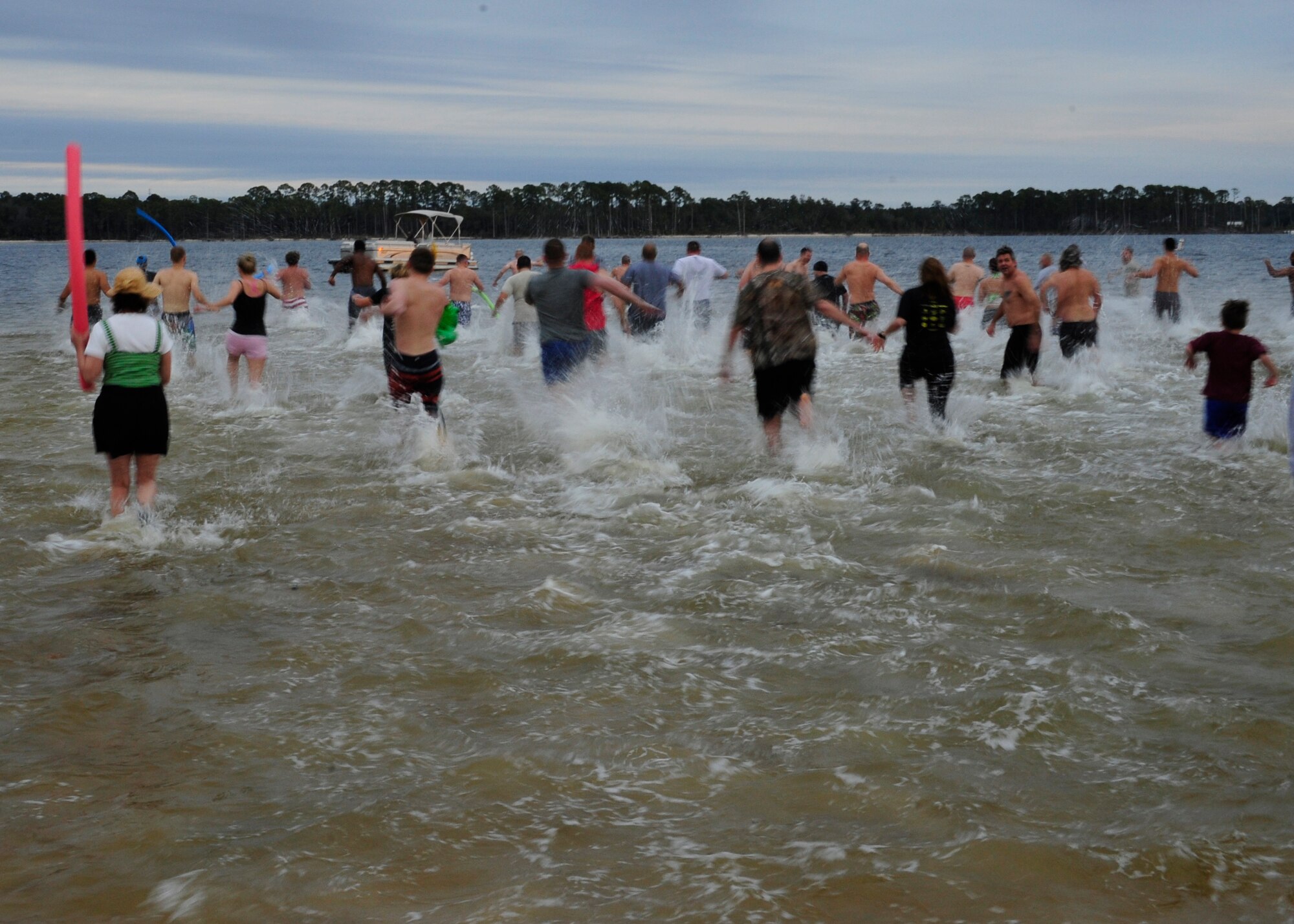 Participants race into the nippy waters of Weekly Bayou during Eglin’s annual Polar Bear Plunge event at Post’l Point, Jan. 9.  Approximately 50 people braved frigid morning temperatures to rush into the 57 degree water.  According to local weather reports, it was 32 degrees with a 27 degree wind chill factor. (U.S. Air Force photo/Ilka Cole) 