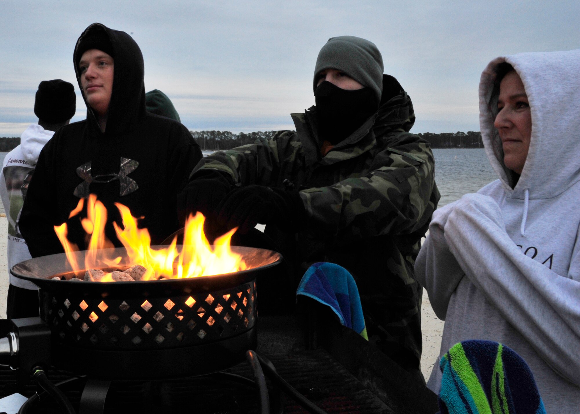 Members of Team Eglin gather around a fire pit at Post’l Point minutes before Eglin’s annual Polar Bear Plunge, Jan. 9.  Approximately 50 people braved frigid morning temperatures to rush into the 57 degree water. According to local weather reports, it was 32 degrees with a 27 degree wind chill factor. (U.S. Air Force photo/Ilka Cole)