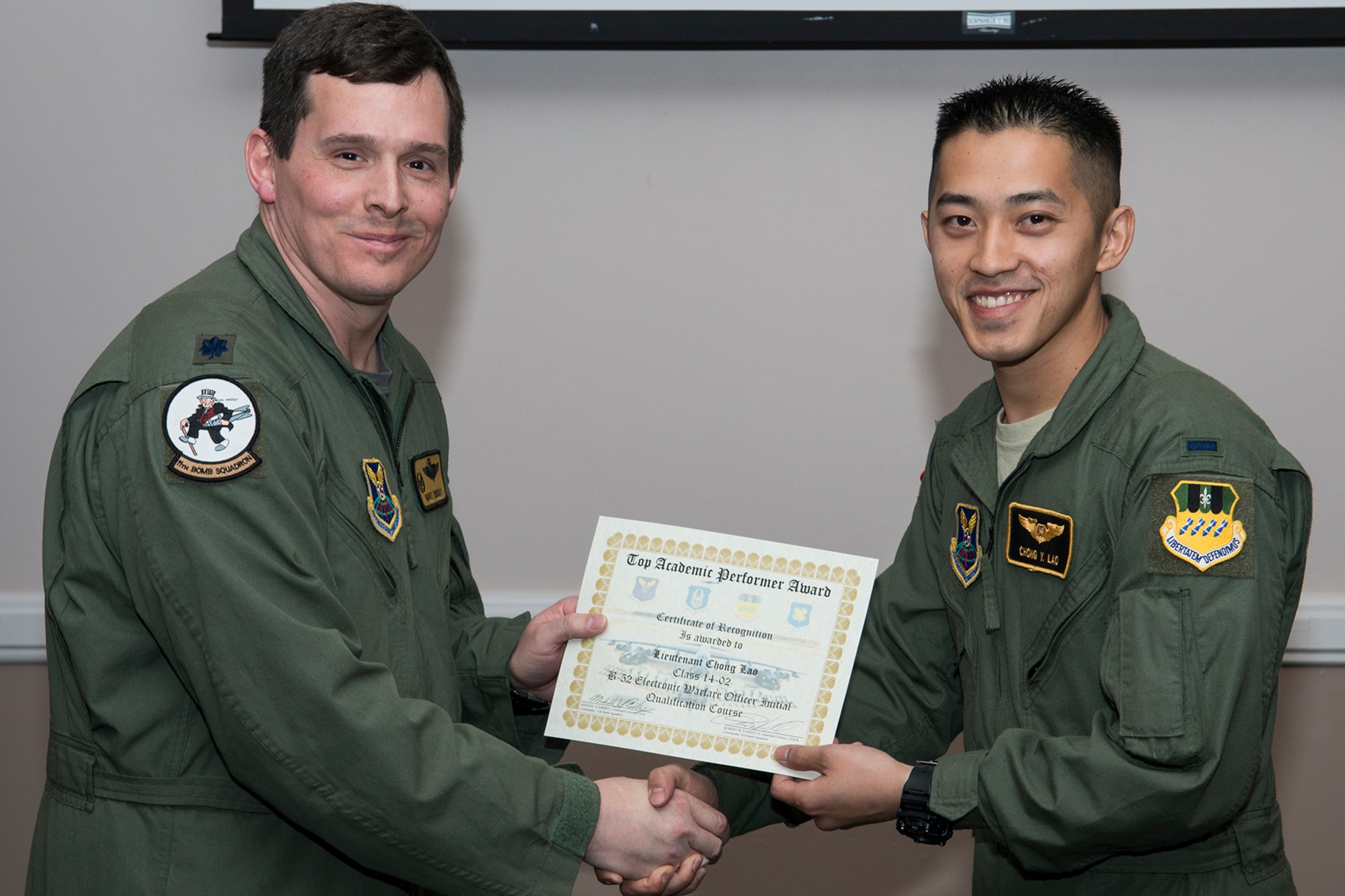 U.S. Air Force Lt. Col. Michael Rimsky, 11th Bomb Squadron commander, presents the Top Academic Performer Award to 1st Lt. Chong Lao during a graduation ceremony, Jan. 9, 2015, Barksdale Air Force Base, La. Lao is a student of the B-52 Formal Training Unit class 14-02 and graduated with the highest academic scores in the Initial B-52 Electronic Warfare Officer Qualification course. (U.S. Air Force photo by Master Sgt. Greg Steele/Released)