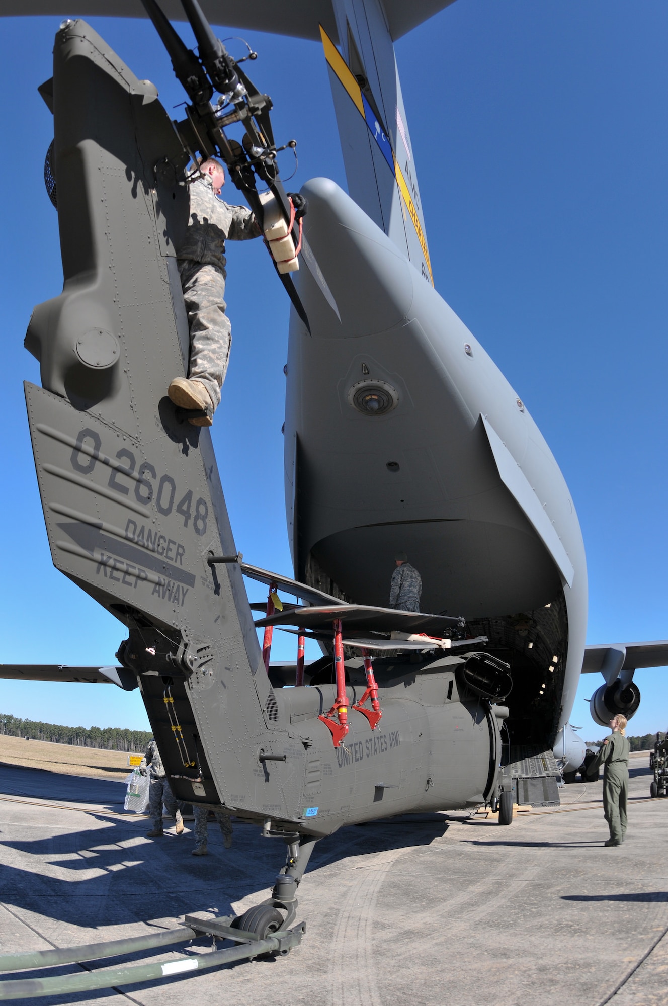 U.S. Soldiers from Company A, 1-111th Aviation Battalion, South Carolina Army National Guard, load a UH-60 Black Hawk onto a C-17 Globemaster III with loadmasters from the 701st Airlift Squadron, 315th Airlift Wing, Joint Base Charleston, during drill weekend at McEntire Joint National Guard Base, Eastover, South Carolina, January 10, 2015. The joint training exercise allows both units to gain knowledge, practice, and experience loading a UH-60 Black Hawk, and provides an opportunity for the South Carolina Army National Guard to meet the Army’s Future Force projection of a knowledge-based component of a joint, interagency, intergovernmental, multi national (JIIM) force. (US Army National Guard Photo by Staff Sgt. Di Giovine)