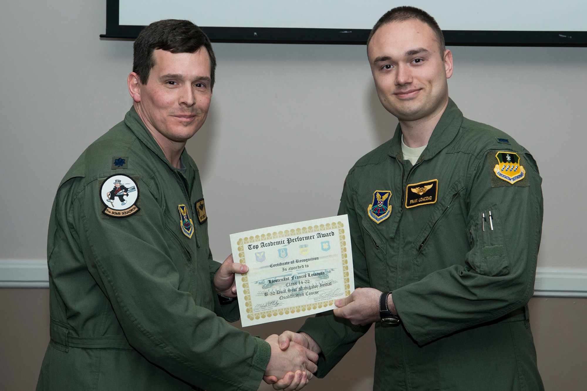 U.S. Air Force Lt. Col. Michael Rimsky, 11th Bomb Squadron commander, presents the Top Academic Performer Award to 1st Lt. Francis Loiacono during a graduation ceremony, Jan. 9, 2015, Barksdale Air Force Base, La. Loiacono is a student of the B-52 Formal Training Unit class 14-02 and graduated with the highest academic scores in the Initial B-52 Dual Seat Navigator Qualification course. (U.S. Air Force photo by Master Sgt. Greg Steele/Released)