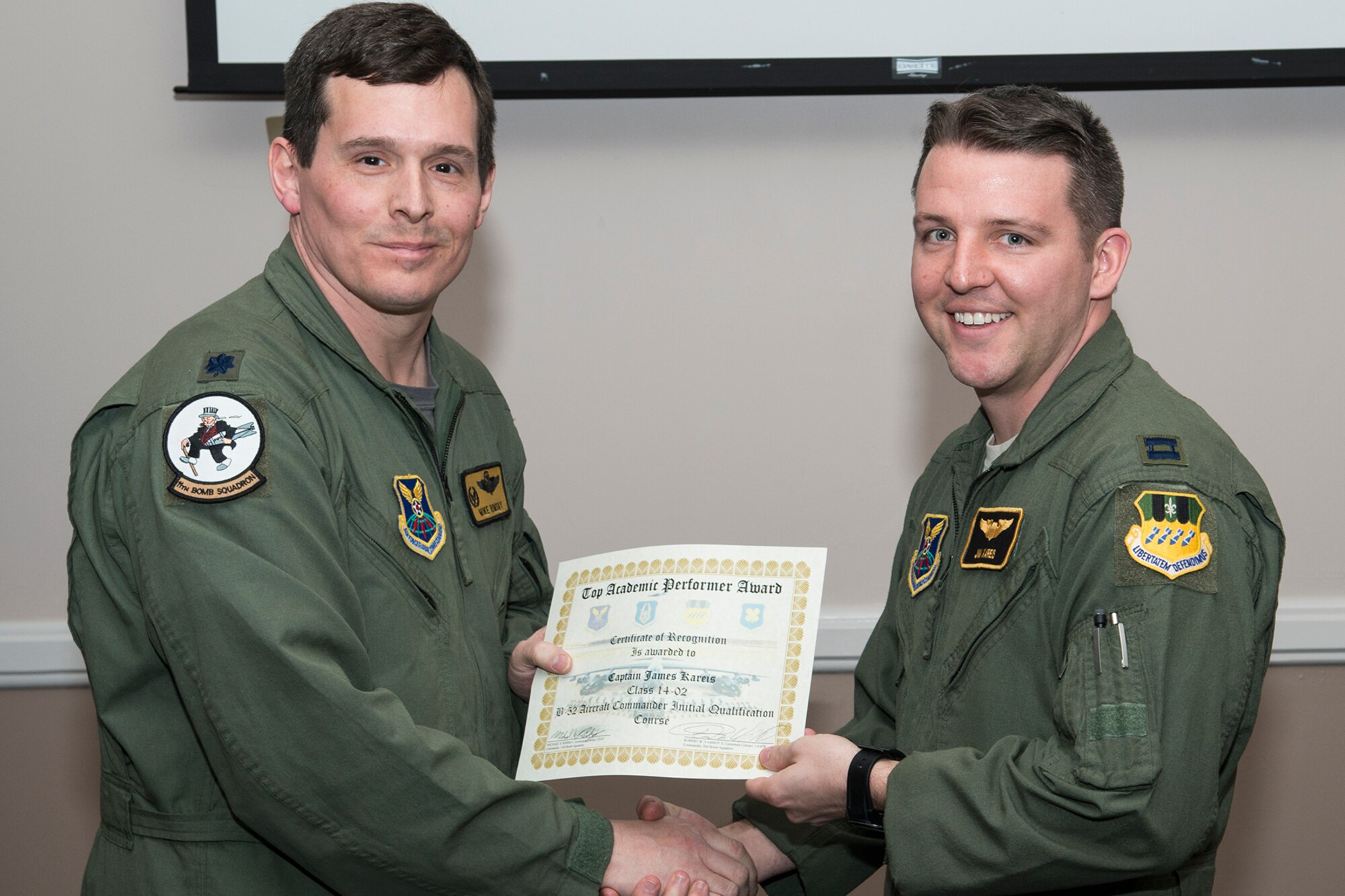 U.S. Air Force Lt. Col. Michael Rimsky, 11th Bomb Squadron commander, presents the Top Academic Performer Award to Capt. James Kareis during a graduation ceremony, Jan. 9, 2015, Barksdale Air Force Base, La. Kareis is a student of the B-52 Formal Training Unit class 14-02 and graduated with the highest academic scores in the Initial Aircraft Commander Qualification course. (U.S. Air Force photo by Master Sgt. Greg Steele/Released)