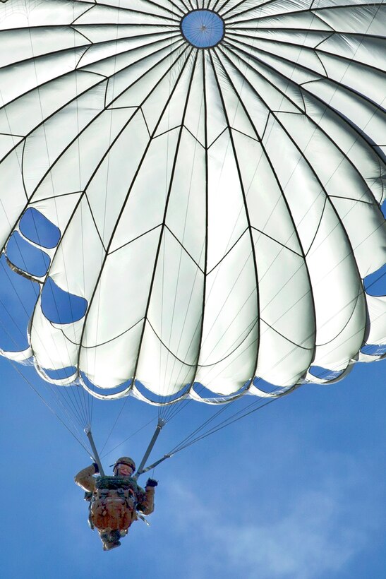 U.S. Air Force Capt. Vince Koziol descend with a parachute from a C-130 Hercules during what's called Jump Week on Yokota Air Base, Japan, Jan. 7, 2015. Koziol is flight commander, 31st Rescue Squadron.