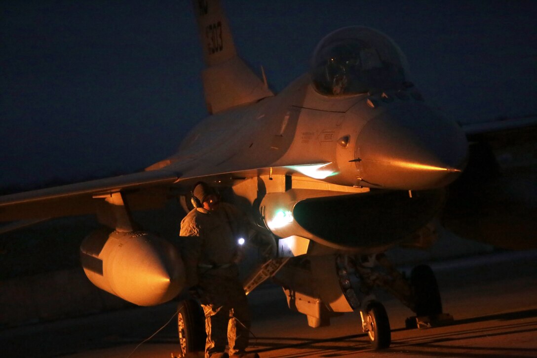 Airmen perform preflight checks on an F-16C Fighting Falcon before a training mission early in the morning during an exercise at Atlantic City Air National Guard Base, N.J, Jan. 9, 2015.