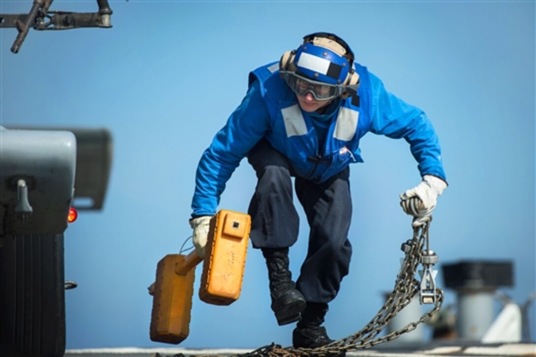 U.S. Navy Seaman Thoren Pond removes chocks and chains from an MH-60S Seahawk helicopter during flight operations on the guided-missile destroyer USS Mitscher in the Persian Gulf, Jan. 7, 2015. Pond is a boatswain's mate assigned to Helicopter Sea Combat Squadron 26. The destroyer is supporting Operation Inherent Resolve, which includes strike operations in Iraq and Syria as directed.