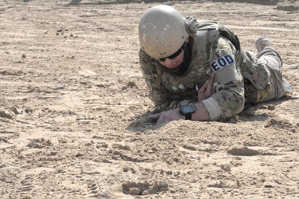 Staff Sgt. Ace, an explosive ordnance disposal technician, works to unbury a simulated improvised explosive device during a training exercise Dec. 30, 2014, in Southwest Asia. EOD Airmen train on IEDs and suicide bomber scenarios as well as suspicious packages and suspicious vehicles. (U.S. Air Force photo/Tech. Sgt. Marie Brown)
