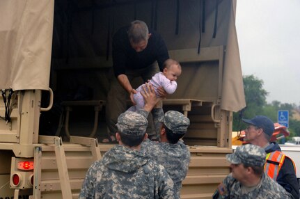 Guardsmen from the 1176th Transportation Company, Tennessee Army National Guard, stationaed in Smyrna, Tenn., help offload victims rescued from their homes due to severe flooding in Gallatin, Tenn. on May 2, 2010. Storms caused severe weather conditions throughout the South, forcing many residents to evacuate their homes.