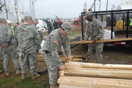 Members of the Louisiana National Guard's 1022nd Engineer Company, of the 527th Engineer Battalion, load oil booms and wooden stakes onto boats at the Breton Sound Marina in Hopedale, La., May 3, 2010. The 1022nd is responding in support of operations related to the oil spill off the coast of Louisiana.