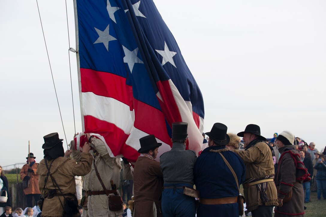 Volunteers reenacting as American militiamen in the War of 1812 catch the flag as it is lowered at the Jean Lafitte National Historic Park and Preserve Jan. 10, 2015. The park hosted a series of living history events on the Chalmette Battlefield in Chalmette, La., that commemorated the bicentennial of the 1815 Battle of New Orleans.  