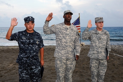 Army Spc. Carlos Baptista (middle) of the Rhode Island Army National Guard’s 115th Military Police Battalion, takes the U.S. Oath of Allegiance during his naturalization ceremony at Naval Station Guantanamo Bay, April 19, 2010. Deployed to Joint Task Force (JTF) Guantanamo, Baptista was born in Cape Verde.