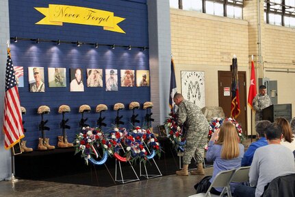 A Soldier lays a wreath in front of a memorial to a fallen comrade to mark the 10th anniversary of the Louisiana National Guard's C Co., 2nd Battalion, 156th Infantry Regiment, 256th Brigade Combat Team’s 2004-2005 deployment to Iraq where eight of the unit’s soldiers lost their lives soldiers during a ceremony in Houma, La., Jan. 10, 2015. The unit was joined for the ceremony by their brethren from the New York National Guard's 1st Battalion, 69th Infantry Regiment, which was the unit’s higher headquarters during the deployment.