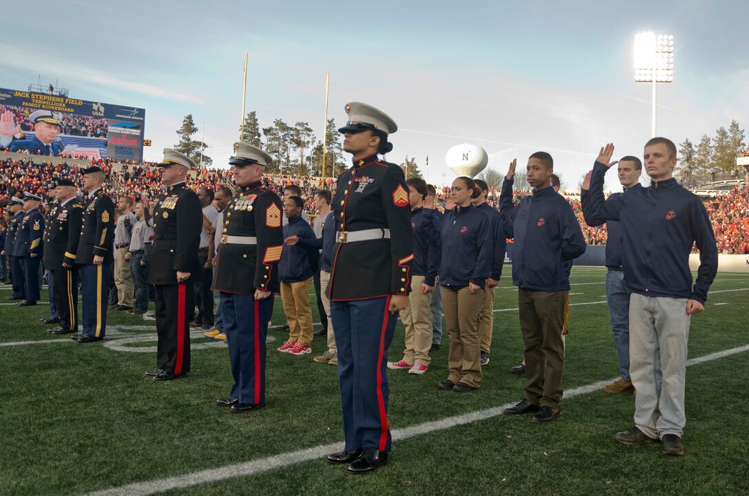 Members of Recruiting Station Baltimore’s delayed entry program, led by Brig. Gen. Kevin J. Killea, the commanding general of Marine Corps Warfighting Laboratory, participate in a joint service oath of enlistment ceremony during the Military Bowl at Navy-Marine Corps Memorial Stadium in Annapolis, Maryland, Dec. 27, 2014. The oath was administered by Rear Adm. Stephen P. Metruck, commander of the Fifth Coast Guard District. (U.S. Marine Corps photo by Sgt Bryan Nygaard/Released)